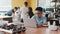 Schoolboy coding on a laptop sitting at the desktop with a joystick, VR headset and chassis of a moving robot in a class