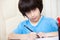 Schoolboy doing homework with pen