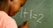 Schoolboy doing mathematics on chalkboard in classroom 4k