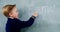 Schoolboy doing maths on chalkboard