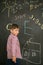 Schoolboy draws chalk on a school board