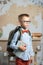 Schoolboy dressed in glasses and a backpack standing in the classroom