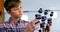 Schoolboy experimenting molecule model in laboratory at school