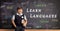 Schoolboy in front of a blackboard with hello written in different languages