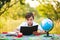 Schoolboy in garden at table intently reading book outdoors