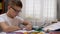 Schoolboy with Glasses Writes with Pen in Notebook,Talking on Skype, Waving Hand