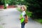 Schoolboy goes to school with a satchel behind shoulders.