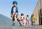 Schoolboy in helmet rollerblading with his friends