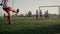 Schoolboy junior league player kicks ball low angle shot