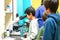 The schoolboy looks through a microscope in a laboratory with curiosity.  Children came on an excursion to the clinic