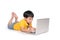 Schoolboy lying down and typing on laptop.