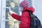 Schoolboy in medical face mask pulls door before entering school.