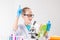 A schoolboy with a microscope and book examines chemicals in test tubes, conducts experiments - a portrait on a white background.