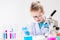 A schoolboy with a microscope examines chemicals in test tubes, conducts experiments - a portrait on a white background. Concept