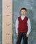 Schoolboy next to the measuring ruler