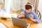 Schoolboy during an online seminar in front of laptop monitor. He makes a presentation on his topic.