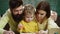 Schoolboy and parents studying. Family with little child boy reading book In playroom class. Happy cute clever boy