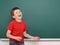 Schoolboy play and laugh near a blackboard, empty space, education concept