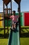 Schoolboy playing on a slide at school playground