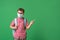 Schoolboy in protective mask, standing against background of a green Board