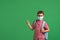 Schoolboy in a protective mask, standing against the background of a green Board