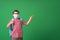 Schoolboy in protective mask, standing against background of a green Board