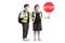 Schoolboy and a schoolgirl with safety vests and a stop sign wearing face masks