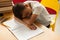 Schoolboy sleeping while studying at table in a classroom