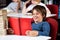 Schoolboy Smiling While Reading Book At Table In