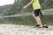 A schoolboy stands in the river on outdoor and destroys a mirrorless photo camera. The concept of obsolescence of technology