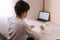 Schoolboy study at desk in his room. Boy use laptop and writing in notebook. Books and tablet on the table. Study home