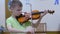 Schoolboy teen child playing violin in music lesson at musical class at school.