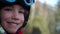 Schoolboy teen in a helmet and goggles sits in a ski lift cabin. The child laughs happily. Fun holidays in the mountains