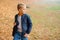 Schoolboy walking in the autumn park. Stylish kid wears jacket, sweater and pants. Autumn fashion, lifestyle