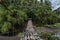 Schoolboy walks on a suspended bamboo floored bridge leading to the jungle in Legazpi, Philippines