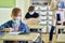 Schoolboy wearing a protective mask writing in the classroom