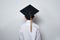 Schoolboy wears the student hat on white background. Back view