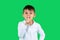 A schoolboy in a white shirt shows his index finger quietly and looks into the camera. Green background. Side space.