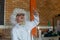 Schoolboy in white wig raising hand in laboratory