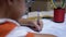 Schoolboy Writes with Left Hand in Notebook, Using Handle. Online Home Training