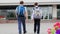 Schoolboys with large backpacks walk to school building