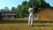 Schoolboys in uniform play cricket on schoolyard in autumn