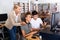 Schoolboys using computer and teacher helping to him in classroo