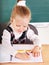 Schoolchild in classroom near blackboard.