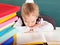 Schoolchild in classroom near blackboard.