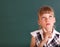 Schoolchild near green blackboard.