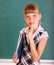 Schoolchild near green blackboard.