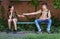 Schoolchildren a boy and a teenage girl are sitting on a bench outside the school building, the boy gives a protective breathing