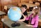 Schoolchildren exploring globe in classroom