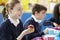 Schoolchildren Sitting At Table Eating Packed Lunch